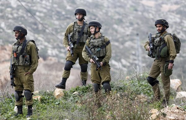 Israeli soldiers stand around near the scene where a Palestinian was shot dead in the West Bank village of Aseera Ashamaliya near Nablus, on Thursday (Reuters photo)